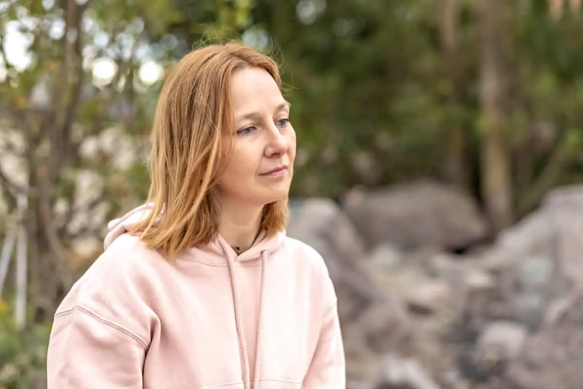 Contemplative woman outdoors considering addiction treatment near Shavano Park